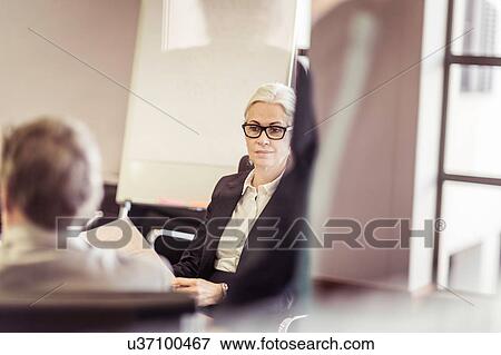 Over shoulder view of mature businesswoman at boardroom meeting View Large Photo Image Stock Photo - Over shoulder view of mature businesswoman at boardroom meeting. Fotosearch