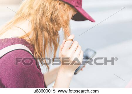 Stock Photography - Over shoulder view of woman using smartphone, London, UK. Fotosearch