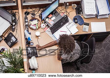 Overhead view of businesswoman talking on landline at office desk View Large Photo Image Stock Image - Overhead view of businesswoman talking on landline at office desk. Fotosearch