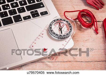 Stock Photography - Overhead view of compass and laptop. Fotosearch