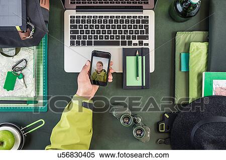Overhead view of man's hand holding smartphone with hiking selfie View Large Photo Image Stock Photography - Overhead view of man's hand holding smartphone with hiking selfie. Fotosearch