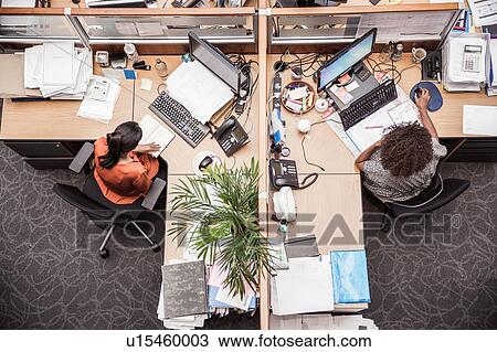 Overhead view of two businesswomen at office desk View Large Photo Image Stock Image - Overhead view of two businesswomen at office desk. Fotosearch