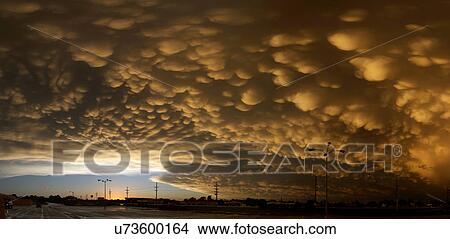 Panoramic image of orange mammatus clouds at sunset, following a day of tornadoes and severe storms, Dodge City, Kansas View Large Photo Image Picture - Panoramic image of orange mammatus clouds at sunset, following a day of tornadoes and severe storms, Dodge City, Kansas. Fotosearch