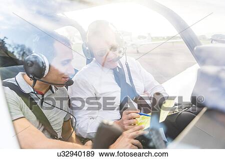 Pilot and co-pilot sitting in aircraft, talking through flight plan View Large Photo Image Stock Photo - Pilot and co-pilot sitting in aircraft, talking through flight plan. Fotosearch