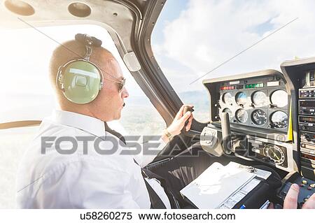 Stock Photography - Pilot in cockpit of aircraft, in flight. Fotosearch