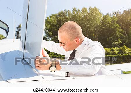 Picture - Pilot inspecting aircraft before flight. Fotosearch