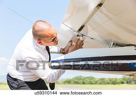 Pilot inspecting aircraft before flight View Large Photo Image Picture - Pilot inspecting aircraft before flight. Fotosearch