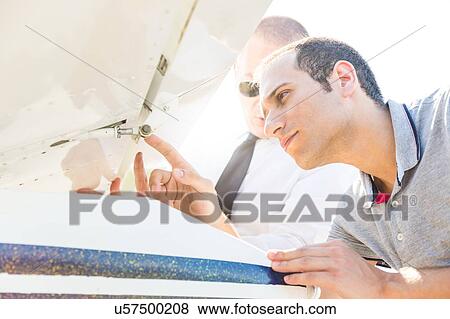 Pilot inspecting aircraft before flight View Large Photo Image Stock Photo - Pilot inspecting aircraft before flight. Fotosearch