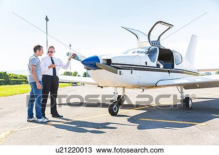 Pilot speaking with aircraft passenger before flight View Large Photo Image Stock Image - Pilot speaking with aircraft passenger before flight. Fotosearch