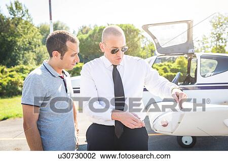 Pilot speaking with aircraft passenger before flight View Large Photo Image Stock Image - Pilot speaking with aircraft passenger before flight. Fotosearch
