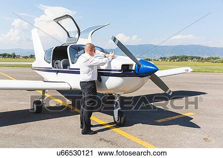 Pilot standing by small aircraft View Large Photo Image Stock Image - Pilot standing by small aircraft. Fotosearch
