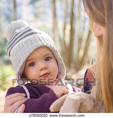 Stock Image - Portrait of baby girl wearing knit hat looking at camera. Fotosearch