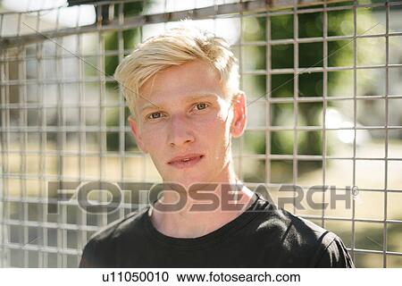 Portrait of blond haired young man by wire fence View Large Photo Image Stock Image - Portrait of blond haired young man by wire fence. Fotosearch