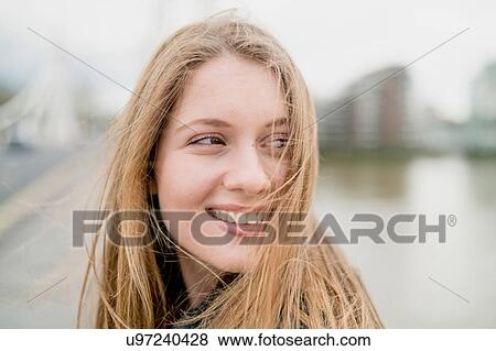 Stock Photo - Portrait of blond haired young woman on waterfront, Battersea Park, London, UK. Fotosearch