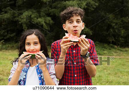 Portrait of brother and sister outdoors, eating watermelon View Large Photo Image Picture - Portrait of brother and sister outdoors, eating watermelon. Fotosearch
