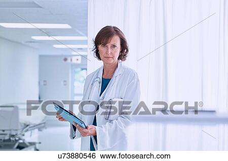 Stock Photograph - Portrait of confident female doctor in hospital ward. Fotosearch