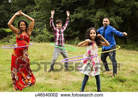 Portrait of family, standing in field, using hula hoops View Large Photo Image Stock Image - Portrait of family, standing in field, using hula hoops. Fotosearch