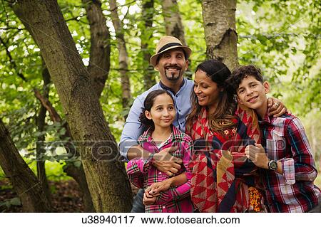 Stock Photo - Portrait of family standing in forest, smiling. Fotosearch