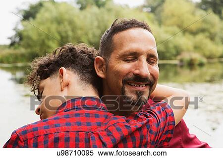 Stock Photography - Portrait of father and son, outdoors, hugging. Fotosearch