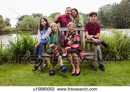 Stock Image - Portrait of four generation family, beside lake, smiling. Fotosearch