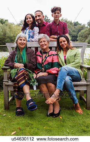 Stock Image - Portrait of four generation family, beside lake, smiling. Fotosearch