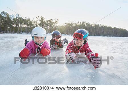Picture - Portrait of girls and boy crawling on frozen lake, Gavle, Sweden. Fotosearch