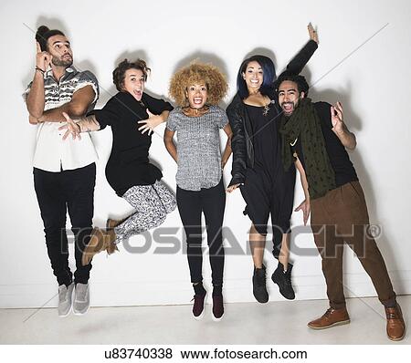 Portrait of group of happy friends against white wall View Large Photo Image Stock Photo - Portrait of group of happy friends against white wall. Fotosearch