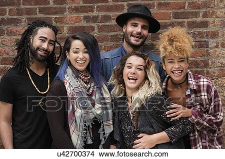 Portrait of happy friends against brick wall View Large Photo Image Picture - Portrait of happy friends against brick wall. Fotosearch