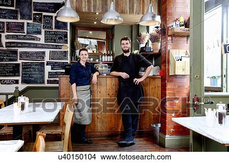 Portrait of male and female baristas leaning on counter of independent coffee shop View Large Photo Image Picture - Portrait of male and female baristas leaning on counter of independent coffee shop. Fotosearch
