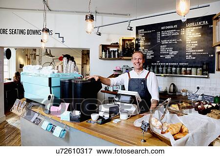 Portrait of male business owner behind counter of independent coffee shop View Large Photo Image Stock Photo - Portrait of male business owner behind counter of independent coffee shop. Fotosearch