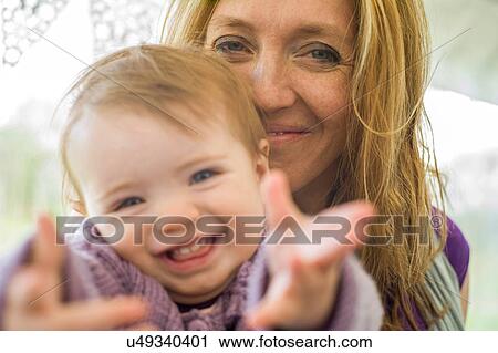 Stock Image - Portrait of mother and daughter looking at camera smiling. Fotosearch