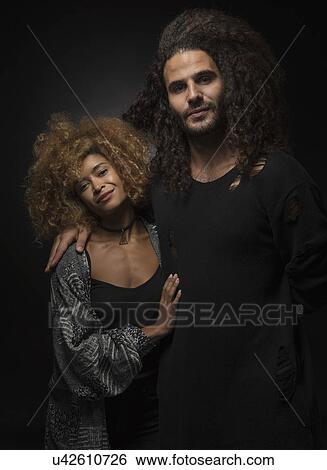 Stock Photograph - Portrait of multi ethnic couple on black background. Fotosearch