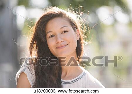 Stock Image - Portrait of pretty woman with long brown hair. Fotosearch