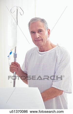 Portrait of senior male patient holding intravenous drip in hospital View Large Photo Image Stock Photograph - Portrait of senior male patient holding intravenous drip in hospital. Fotosearch