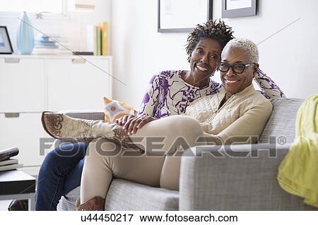 Portrait of smiling women sitting in living room View Large Photo Image Stock Photo - Portrait of smiling women sitting in living room. Fotosearch
