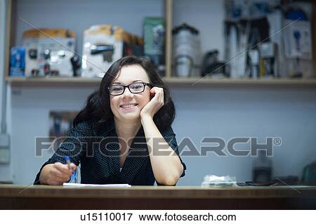 Portrait of woman at counter looking at camera smiling View Large Photo Image Stock Photo - Portrait of woman at counter looking at camera smiling. Fotosearch