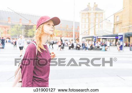 Stock Photo - Portrait of woman wearing baseball cap looking away, London, UK. Fotosearch