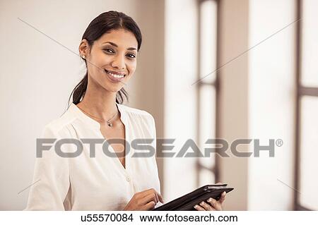 Portrait of young businesswoman using digital tablet in office View Large Photo Image Picture - Portrait of young businesswoman using digital tablet in office. Fotosearch