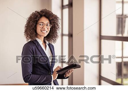 Portrait of young businesswoman using digital tablet in office View Large Photo Image Picture - Portrait of young businesswoman using digital tablet in office. Fotosearch
