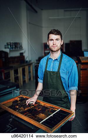 Portrait of young craftsman next to tray of letterpress letters in print workshop View Large Photo Image Picture - Portrait of young craftsman next to tray of letterpress letters in print workshop. Fotosearch