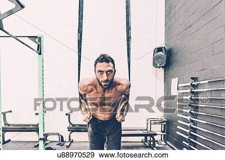 Portrait of young male cross trainer preparing to train on exercise rings in gym View Large Photo Image Stock Photo - Portrait of young male cross trainer preparing to train on exercise rings in gym. Fotosearch
