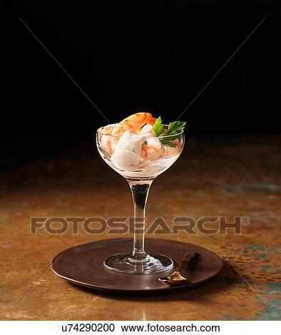 Stock Image - Posh prawn cocktail in wine glass with coriander. Fotosearch