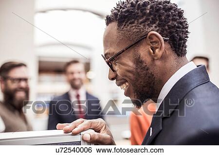 Stock Photograph - Profile of happy young businessman in office. Fotosearch