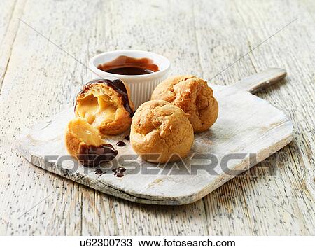 Stock Image - Profiteroles with hot chocolate sauce. Fotosearch