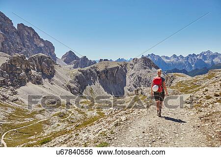 Rear view of female hiker hiking in Dolomites, Sexten, South Tyrol, Italy View Large Photo Image Stock Photograph - Rear view of female hiker hiking in Dolomites, Sexten, South Tyrol, Italy. Fotosearch