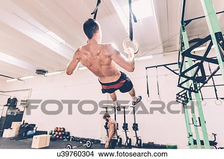 Rear view of male cross trainer training on gymnastic rings View Large Photo Image Picture - Rear view of male cross trainer training on gymnastic rings. Fotosearch