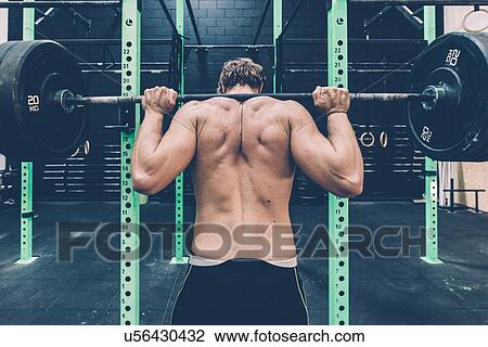 Rear view of male cross trainer weightlifting barbell in gym View Large Photo Image Stock Image - Rear view of male cross trainer weightlifting barbell in gym. Fotosearch
