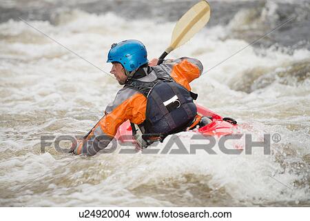 Picture - Rear view of male kayaker paddling River Dee rapids. Fotosearch