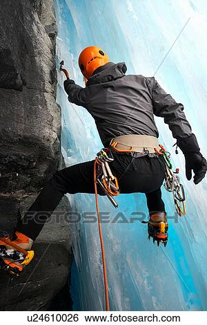 Stock Photograph - Rear view of man in cave ice climbing, Saas Fee, Switzerland. Fotosearch