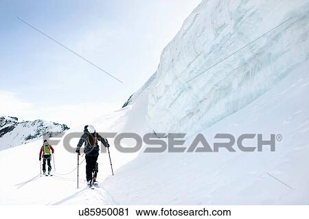 Stock Image - Rear view of mountaineers ski touring on snow-covered mountain, Saas Fee, Switzerland. Fotosearch
